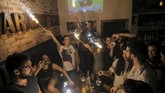 Orang-orang juga merayakan ulang tahun di bar di kota tua di Damascus, Suriah. Warga juga keluar ke jalan-jalan untuk bermain gitar atau sekedar menghabiskan waktu di kafe (REUTERS/Marko Djurica)