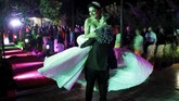 Pengantin pria dibawa di pundak teman-teman dan keluarganya, sementara orang-orang bertepuk tangan di sekitarnya. ia pun mengayunkan sang pengantin ke dalam pelukannya.(REUTERS/Marko Djurica)