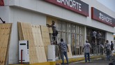 Jelang badai, para pekerja mulai melindungi toko-toko mereka dengan panel kayu di pelabuhan Mazatlan di wilayah Sinaloa, Meksiko (ALFREDO ESTRELLA / AFP)