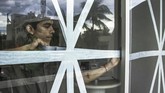 Pekerja menggunakan selotip untuk melindungi jendela dari hurikan Willa (RASHIDE FRIAS / AFP)