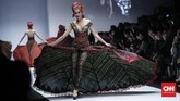 Atasan seolah hanya kain tule transparan dengan sematan bordir serupa sulur. Bawahannya berupa kain panjang sehingga tampilan lebih mirip evening gown nan mewah. Ada pula look kebaya dengan bentuk leher V rendah. (CNNIndonesia/Safir Makki)
