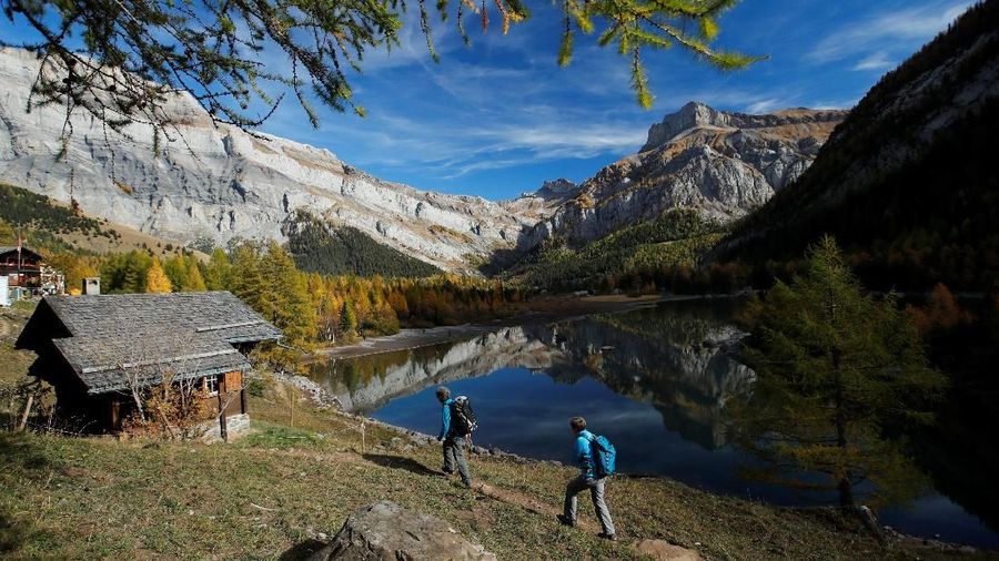 People enjoy a warm autumn day near a lake in Derborence, Switzerland, October 25, 2018. REUTERS/Denis Balibouse