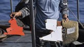 Prajurit TNI AL menunjukan serpihan yang diduga dari pesawat Lion Air JT610 saat pencariaan menggunankan KRI Kobra di perairan Karawang, Jawa Barat, Senin (29/10). (ANTARA FOTO/Hafidz Mubarak A)