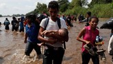Proses verifikasi data yang lama membuat ribuan imigran jengah hingga akhirnya memutuskan untuk menyeberangi Sungai Suchiate dengan berenang. (Reuters/Carlos Garcia Rawlins)