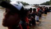 Setelah menempuh perjalanan panjang dari tanah airnya, para imigran tiba di perbatasan Guatemela dan Meksiko pada Minggu (28/10), di mana mereka harus menyeberangi Sungai Suchiate. (Reuters/Carlos Garcia Rawlins)