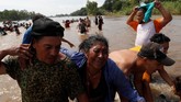 Di sana, para petugas keamanan perbatasan sudah menunggu dengan senapan berisi peluru karet. (Reuters/Carlos Garcia Rawlins)