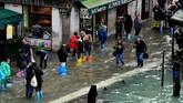 Toko-toko dan restoran setempat tetap digenangi banjir meskipun barikade penahan air pasang telah dipasang di pintu-pintu. (AFP Photo/Miguel Medina)