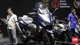 Seorang pengunjung IMOS 2018 berada di stan Yamaha. Ia berdiri di samping Yamaha Tmax. (CNNIndonesia/Safir Makki)