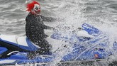 Seorang peserta parade Halloween di East River, New York, Amerika Serikat, berdandan layaknya badut horor sembari menunggangi jet ski. (REUTERS/Carlo Allegri)