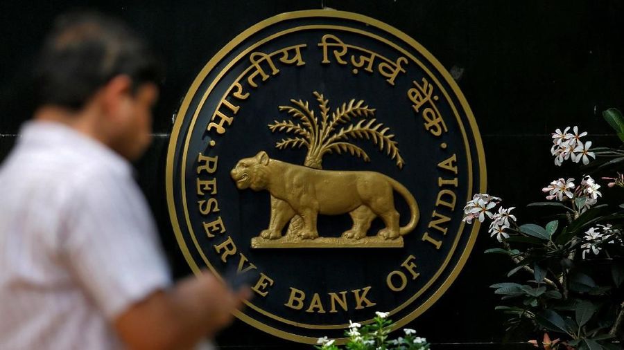 FILE PHOTO: A man checks his phone outside the Reserve Bank of India (RBI) headquarters in Mumbai, India, April 5, 2018. REUTERS/Francis Mascarenhas/File Photo