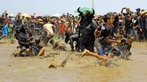 Warga memasuki kubangan yang dijaga kebo-keboan untuk mengambil benih padi yang ditebar. (ANTARA FOTO/Budi Candra)
