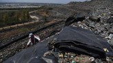 Pekerja terlihat sedang menutupi sampah dengan geomembran agar memaksimalkan hasil gas metana dan tersalurkan dengan baik melalui pipa menuju sumur gas. (ANTARA FOTO/Zabur Karuru)