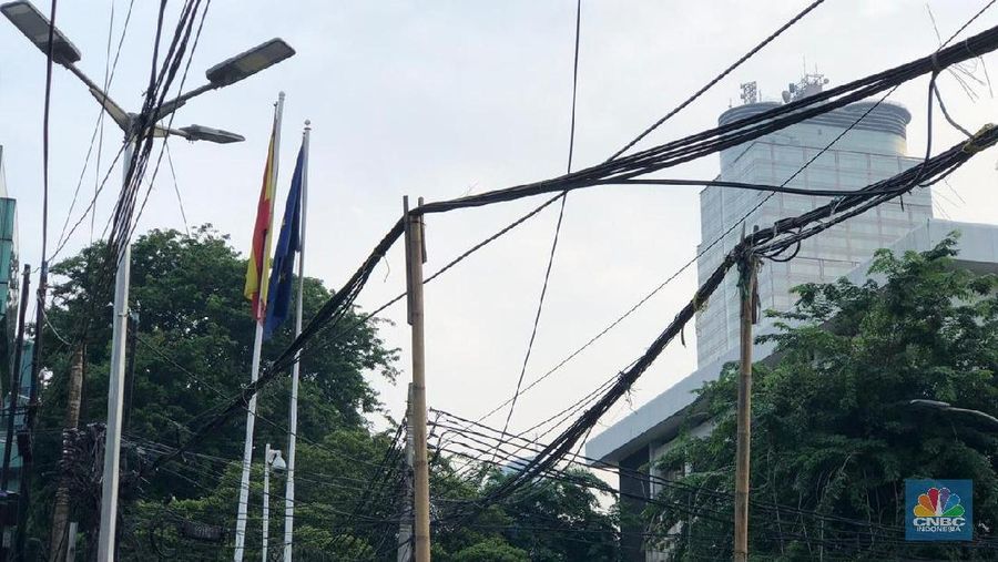 Bagi Anda pengguna jalan yang sering melintasi kawasan Thamrin, Sudirman, Jakarta Pusat, sebaiknya mulai ekstra hati-hati.
Pasalnya, ada dua tiang yang hanya terbuat dari bambu berdiri tegak di tengah jalan KH Wahid Hasyim, Sabang, Jakarta Pusat. Tiang bambu itu ditanam persis di tengah jalan.
Berdasarkan pantauan CNBC Indonesia, kedua tiang bambu setinggi 3 - 5 meter itu untuk menopang kabel listrik dan telepon agar tidak jatuh ke tanah.
Kabel listrik dan kabel telepon yang melintang di perempatan jalan itu memang tampak semrawut. Ada beberapa gulungan kabel yang diikat tidak rapih di sudut-sudut jalan.
Para pengguna jalan di wilayah ini diharapkan hati-hati, lantaran tak ada separator atau rambu jalan yang diletakkan di sekitar bambu sebagai tanda para pengendara harus berhati-hati.
Sukirman, salah seorang petugas jalur pedestrian di kawasan tersebut mengemukakan tiang bambu ini digunakan hanya sementara, sampai proses perbaikan jalur selesai seutuhnya. (CNBC Indonesia/Chandra Gian Asmara)