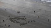 Orang-orang berkumpul di tepi pantai Downhill Beach di Coleraine, Irlandia Utara, 11 November 2018 lalu untuk memperingati seabad usainya Perang Dunia I. (REUTERS/Clodagh Kilcoyne)