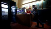 Sang pemilik bioskop Nitsch-Fitz yang berusia 80 tahun, berbincang dengan proyeksionis Wolfgang di meja kasir sementara menunggu calon penonton. (REUTERS/Lisi Niesner)