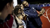 Penyerang timnas Perancis Kylian Mbappe melakukan selfie dengan penggemar sebelum menjalani latihan. (REUTERS/Benoit Tessier)