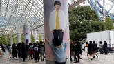 Seorang wanita memeluk foto seorang personel BTS yang ditempel di pilar gedung Tokyo Dome, lokasi konser boyband Korea yang diadakan pada 13 November lalu. (REUTERS/Kim Kyung-Hoon)