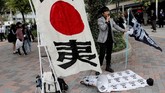 Seorang pria yang kontra dengan kehadiran BTS mengungkapkan kekesalannya dengan pengeras suara dan sejumlah pamflet. (REUTERS/Kim Kyung-Hoon)