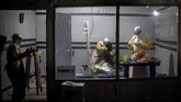 Sejumlah petugas kesehatan diturunkan untuk menangani pasien-pasien Ebola yang belum terkonfirmasi agar penularan tak terus berlanjut. (Photo by John WESSELS/AFP)