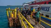 Wisatawan mancanegara berjalan di dermaga pelabuhan kapal penumpang usai tiba di Karimunjawa, Jepara, Jawa Tengah. Kepulauan yang terletak di utara Pulau Jawa ini termasuk wilayah administratif Kabupaten Jepara. Terdapat 27 pulau dengan luas daratan kurang lebih 1.500 hektare dan perairan seluas 110 ribu hektare.
