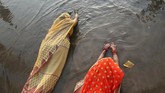 Seorang pemuja membawa 'tika' saat menaikkan doa-doa kepada Matahari dalam Festival Chhat di sepanjang sungai Bagmati di Kathmandu, Nepal. (REUTERS/Navesh Chitrakar)
