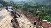 Sejumlah pekerja menyelesaikan pembangunan dinding beton penahan longsor di jalur Puncak, Bogor, Jawa Barat, Selasa (13/11). (ANTARA FOTO/Yulius Satria Wijaya)