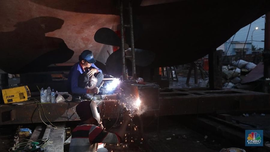 Sejumlah tukang menyelesaikan pekerjaan kapal nelayan di Galangan Kapal Muara Angke, Senin (19/11). Para pekerja ini memulai aktivitasnya sejak pukul 09.00 WIB hingga 19.00 WIB setiap harinya. Galangan Kapal tersebut menjadi tempat perbaikan kapal di Jakarta Utara ditaksir revitalisasi menelan biaya dari puluhan hingga ratusan juta.   Satu kapal angkut barang seberat 350 ton bisa dikerjakan oleh kurang lebih 30 pekerja. (CNBC Indonesia/Muhammad Sabki)