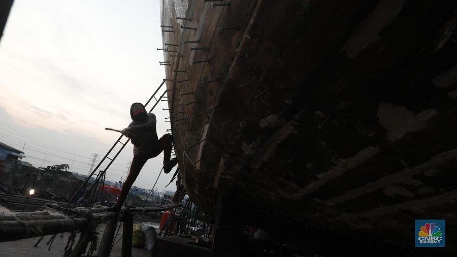 Sejumlah tukang menyelesaikan pekerjaan kapal nelayan di Galangan Kapal Muara Angke, Senin (19/11). Para pekerja ini memulai aktivitasnya sejak pukul 09.00 WIB hingga 19.00 WIB setiap harinya. Galangan Kapal tersebut menjadi tempat perbaikan kapal di Jakarta Utara ditaksir revitalisasi menelan biaya dari puluhan hingga ratusan juta.   Satu kapal angkut barang seberat 350 ton bisa dikerjakan oleh kurang lebih 30 pekerja. (CNBC Indonesia/Muhammad Sabki)