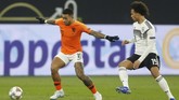 Gelandang serang timnas Belanda Memphis Depay berduel dengan Leroy Sane. Skor 2-0 untuk tuan rumah bertahan hingga akhir babak pertama. (REUTERS/Leon Kuegeler)
