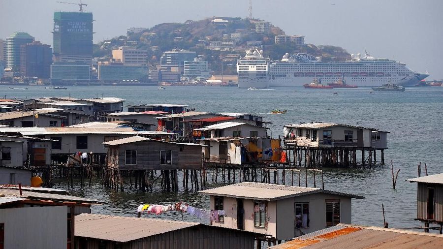 A large cruise ship is docked opposite the stilt house village called Hanuabada, located in Port Moresby Harbour, Papua New Guinea, November 19, 2018. Picture taken November 19, 2018. REUTERS/David Gray
