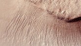Bagian permukaan Mars menunjukkan banyak saluran pada lereng curam di cekungan Hellas. Para ilmuwan telah menemukan bukti pertama bahwa air asin dapat mengalir di permukaan Mars selama musim panas planet ini. (REUTERS/NASA)