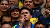 Salah satu fan Boca Juniors mencium kalung rosario demi keberuntungan timnya saat leg pertama final Copa Libertadores. Masih banyak fan dari kedua tim yang percaya hal-hal mistis di sepak bola. (REUTERS/Marcos Brindicci)
