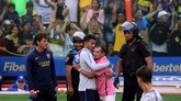 Striker Boca Juniors Carlos Tevez meladeni salah satu fan yang masuk lapangan dan memeluknya pada sesi latihan jelang bertandang ke markas River Plate. (REUTERS/Marcos Brindicci)
