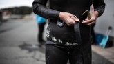 Mereka mengenakan pakaian lengkap untuk menyelam, dari topeng yang menutupi mata hingga hidup dan wetsuit hitam. (Martin BUREAU / AFP)