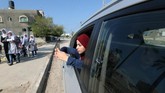 Wanita Palestina Fatma Abu Musabbeh menggunakan ponselnya untuk mengambil gambar saat dia melihat keluar dari jendela mobil di Jalur Gaza tengah. (REUTERS/Mohammed Salem)
