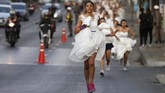 Namun berbeda dari kompetisi lari biasa, mereka harus memakai gaun pengantin saat berlari di jalanan. (REUTERS/Soe Zeya Tun)