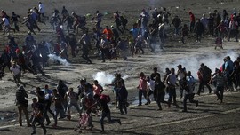 FOTO: Panas Gas Air Mata Adang Imigran Honduras ke AS