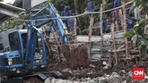 Alat berat yakni eksavator diterjunkan untuk membersihkan tanah dan puing bangunan pascaperistiwa longsor di Kalisari, Pasar Rebo, Jaktim. (CNN Indonesia/Andry Novelino)