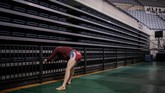 Dalam pertandingan gulat ini, kekuatan dan tehnik adalah kuncinya. Seorang pegulat terlihat sedang melakukan peregangan. (Photo by Ed JONES / AFP)