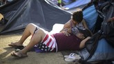 Banyak dari mereka yang merupakan pasangan, seperti Lilian (23) dan Ronny (25) dari Honduras yang sedang beristirahat di tempat perlindungan sementara di Tijuana, Meksiko. (REUTERS/Lucy Nicholson)