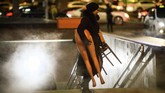 Seorang perempuan membawa separuh manekin keluar dari terminal bawah tanah di Moskow, Rusia. (Photo by Mladen ANTONOV / AFP)