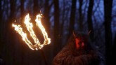 Seorang pria yang mengenakan kostum setan berdiri di depan gua pasir di sebuah desa di Svitava, dekat kota Cvikov, Republik Ceko. (REUTERS/David W Cerny)