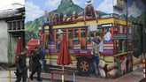 Dua orang polisi berjalan melewati sebuah gambar mural. Penyelenggara menyatakan Mural Festival diselenggarakan untuk mengubah pandangan negatif terkait San Carlos. (Photo by JOAQUIN SARMIENTO / AFP)