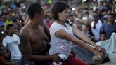 Di tengah ketidakpastian dan harapan, pasangan ini menyempatkan diri menari untuk bersantai sejenak di kamp migran di Meksiko. (REUTERS/Ueslei Marcelino)