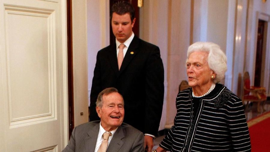 FILE PHOTO: Former U.S. President George H. W. Bush (L) and former first lady Barbara Bush enter the East Room of the White House before the ceremony unveiling the official White House portraits of former President George W. Bush and former first lad