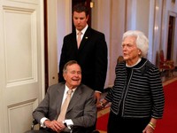 FILE PHOTO: Former U.S. President George H. W. Bush (L) and former first lady Barbara Bush enter the East Room of the White House before the ceremony unveiling the official White House portraits of former President George W. Bush and former first lad