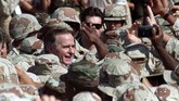 Presiden George H. W. Bush dikelilingi prajurit AS saat seremoni penyambutan di kota Dhahran, Arab Saudi. Selama periode 1989-1993, Bush menerapkan sejumlah kebijakan luar negeri yang didominasi pendekatan militer. (REUTERS/Terry Bochatey)