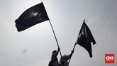 Bendera hitam bertuliskan kalimat tauhid berkibar di acara Reuni Aksi 212, Monas, Jakarta Pusat. Bendera ini pernah dipajang di tembok rumah Rizieq Shihab di Arab Saudi, namun dipermasalahkan karena ada larangan di sana. (CNN Indonesia/Harvey Darian)