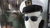Topi kapten putih ini juga sering dipakai Hefner, lengkap dengan kacamata hitam keluaran Gucci. (Photo by Robyn Beck / AFP)
