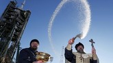 Seorang imam Ortodoks memberikan air suci di depan pesawat ruang angkasa Soyuz MS-11 dari Baikonur Cosmodrome, Kazakhstan. (REUTERS/Shamil Zhumatov)